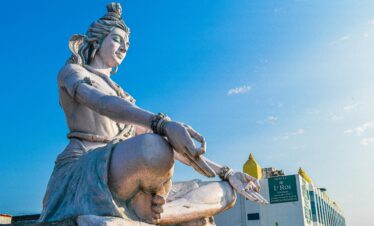 Magnificent low-angle view of Lord Shiva statue against a blue sky in Haridwar, India.