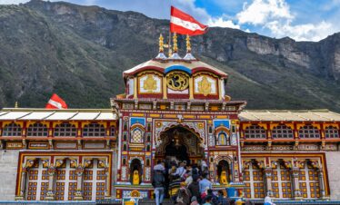 Vibrant view of Shree Badrinath Temple with pilgrims gathered around, set against a mountainous backdrop.