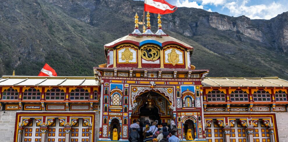 Vibrant view of Shree Badrinath Temple with pilgrims gathered around, set against a mountainous backdrop.