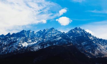 Stunning winter view of snow-covered Himalayan mountains under a bright blue sky.